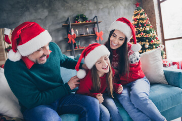 Fototapeta premium Portrait of overjoyed friendly people sitting couch have good mood play tickle laugh fairy newyear time indoors