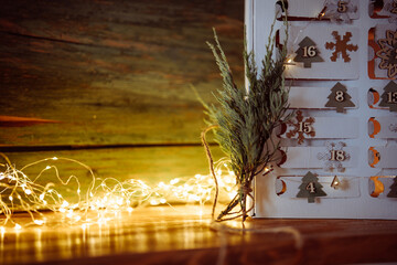 Advent calendar with christmas lights on rustic wood. Handmade eco friendly christmas packaging. 