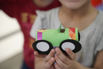 little kid doing car arts and crafts with recycled materials toilet paper rolls and papers. kids...