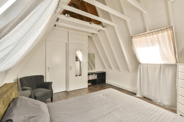 a bedroom with a bed, chair and window in the attic style room that has been used for many years