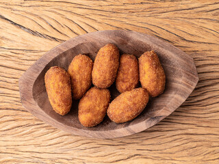 Typical brazilian jerked meat stuffed snack on a plate over wooden table