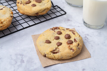 Chocolate chip cookies over marble table with milk