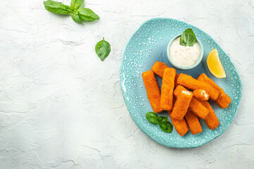 Crumbed fish sticks served with lemon and tartar sauce. Long banner format. top view