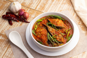 Thai Sour soup with catfish and water mimosa in white bowl on wooden table