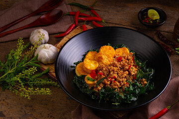 Stir fried basil with minced pork and eggs bean curd in black plate.Thai spicy food