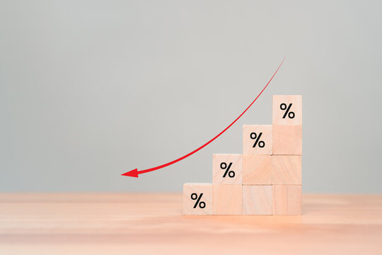 Wooden cube blocks with percentage sign and down arrow icon. Business concept of income decreased, investment reduce,  financial recession crisis, interest rate decline, risk management.