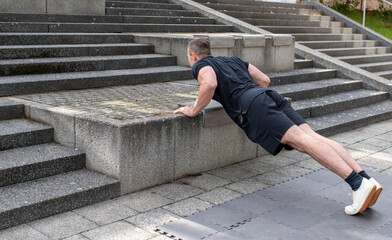 Incline push-up doing by a young athletic man. Push-up modification for beginners - Powered by Adobe