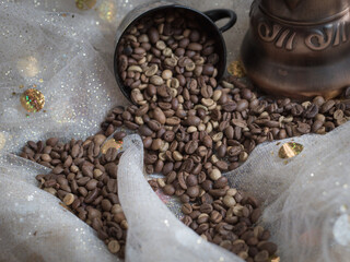 coffee beans are scattered on the table next to the Turk and the cup 