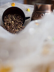 coffee beans are scattered on the table next to the Turk and the cup 