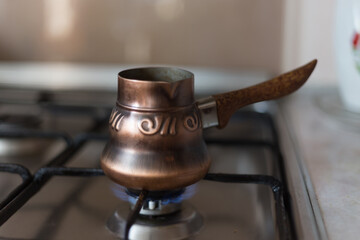 coffee is brewed on the stove in a copper Turk at home