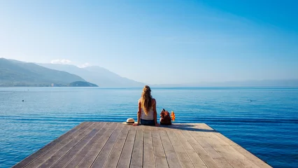 Keuken spatwand met foto Woman sitting on wooden pier at Ohrid lake shore in Macedonia- tour tourism,travel destination,vacation concept © M.studio