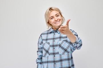 Portrait of confident girl chooses you points finger at camera isolated on white studio background. Welcome gesture, join our team concept.