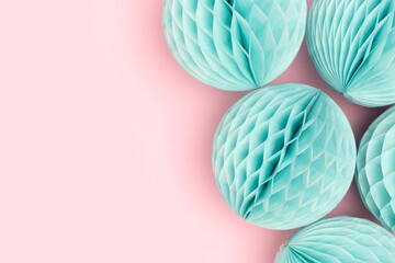 Blue tissue paper balls on a pink background. Creative festive concept.