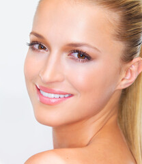 Fototapeta premium Portrait, beauty and smile of a woman closeup in studio on a white background for natural wellness or cosmetics. Face, skincare and foundation with a happy young model at the salon for dermatology