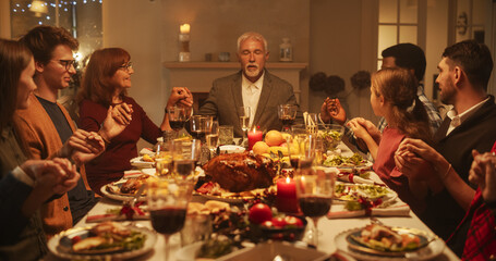 Religious Family Celebrating Christmas at Home. Relatives and Friends Praying and Holding Hands, Blessing Food Before Eating Dinner. Christians Thanking God for Providing a Delicious Turkey Roast