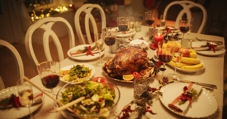 Close Up of a Delicious Turkey Roast with Baked Potatoes on a Festive Table. Tasty Meals and Stylish Decorations Prepared for a Family Dinner at Home. Anonymous People Dining Behind a Table