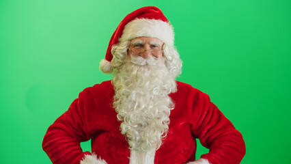 Studio Shot Isolated Mockup Template: Jolly Santa Claus Standing On Green Screen Chromakey Background With Hands Crossed, Looks At The Camera Cheerfully. Christmas, New Year, Celebration
