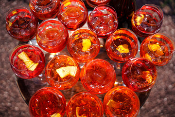 Lots of wine cocktail glasses on the table in the garden.