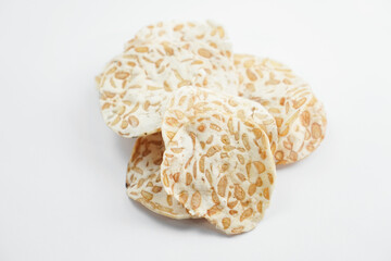 Keripik Tempe or Tempeh Chips are made from soybeans mixed with rice flour then sliced ​​thinly. Isolated on white background.