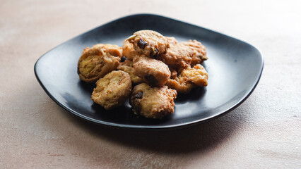 Fried tofu on a black plate. Single shot. Table Top.