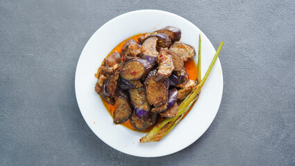 (Terong Balado) Balado eggplant served on a white plate. Single object. Table tops.