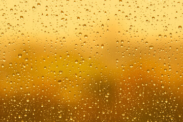 Water drops on glass surface over blurry colored background