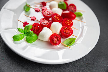 Caprese canapés mozzarella and tomato appetizer salad on a skewer finger food delicious healthy eating cooking appetizer meal food snack on the table copy space food background rustic top view 