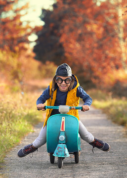 viel Spaß im Herbst, kleiner Junge fährt Moped