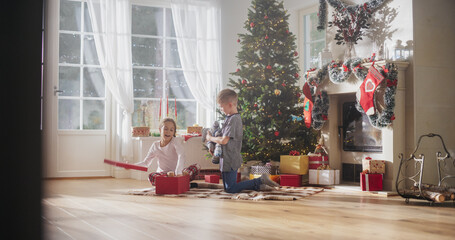 Cute Children Impatient to Get Their Gifts from Under the Christmas Tree at Home. Happy Little Boy and Girl Waking Up on Holiday Morning to Receive New Toys