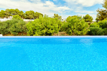 Bright blue swimming pool waters and green trees