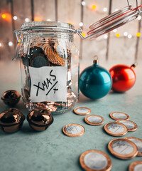Large money jar filled with coins collecting and saving for Christmas surrounded by decorations 3d render