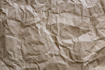 Sheet of crumpled brown paper, waste recycling concept, nature conservation, waste sorting. Designer craft paper texture. Blank sheet of biodegradable packaging paper-cardboard.