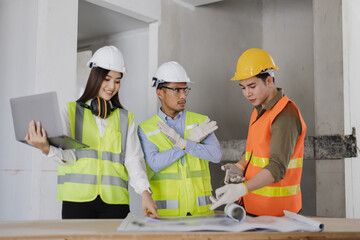 Asian engineers team working and design building project at construction in site office, Engineers meeting together to planning concept.