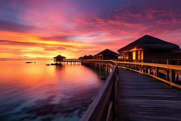 Fototapeta na wymiar Idyllic Maldives sunset, overwater villas, sandy beach a travel daydream