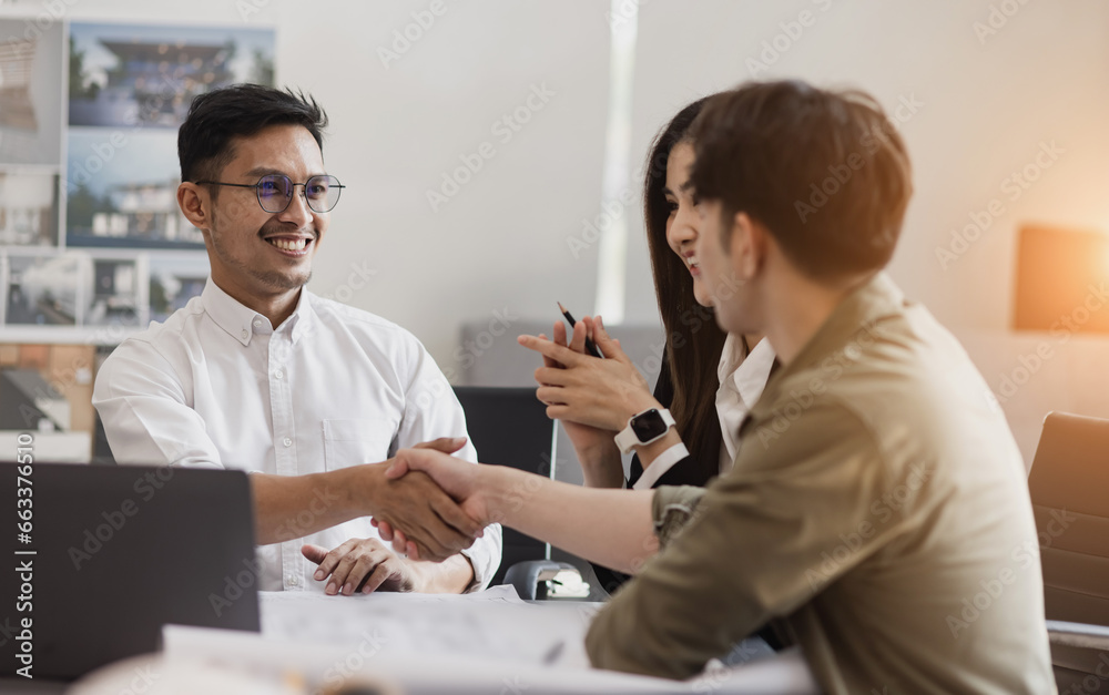 Wall mural people hand shake in office desk, business man shaking hands after contract signing.