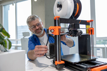 Man designer printing design using 3D printer in office.