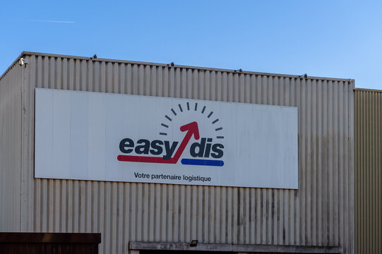 un panneau avec le logo et le symbole de la soci&eacute;t&eacute; Easydis de logistique et de transport sur un batiment industriel.