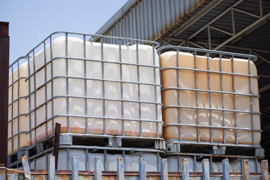 used IBC container, or Intermediate Bulk Container with the factory background. plastic chemical storage with the industry cargo.