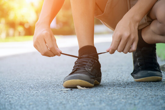 Closeup image of tying shoelace getting ready for exercise afterschool of asian schoolboy, concept of preventing the risk of falls of all people around the world.