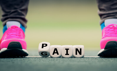 Dice form the words pain and gain. Symbol for the expression 'no pain no gain'.