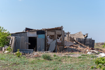 An old ruined wooden house. Broken walls, a ruined roof. Piles of garbage. Natural disasters, war, earthquake