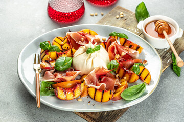 Fresh salad with grilled peach, prosciutto ham, basil and burrata, Restaurant menu, dieting, cookbook recipe top view