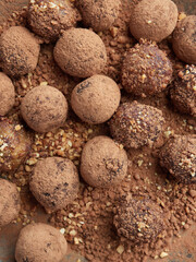 Close up view of chocolate bliss balls dusted with cacao and nuts. Sugar free truffles or energy balls.