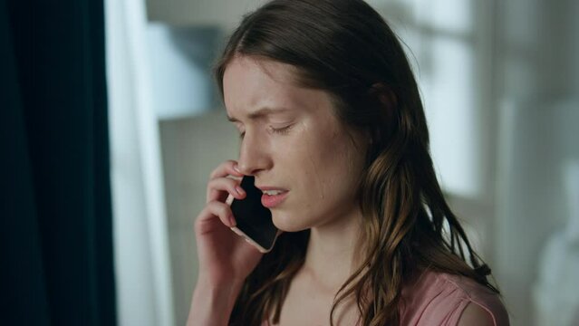 Stressed girl calling smartphone in dark room closeup. Upset young woman talking