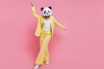 Full length portrait of excited crazy classy person 3d panda mask dancing clubbing empty space ad isolated on pink color background © deagreez