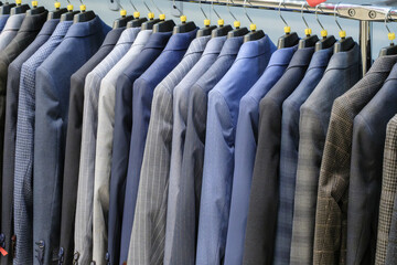 Racks with different men's suits in a men's clothing boutique.