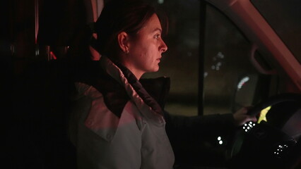 Woman driving moving truck at night. Female driver paying attention to highway road in evening...