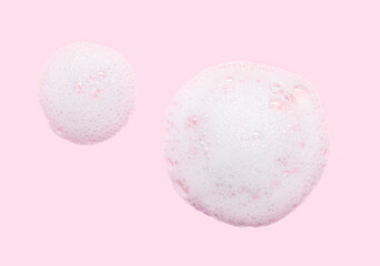 Skincare cleanser foam texture with bubbles isolated on pastel pink background. Soap shampoo face wash cleansing musse product sample