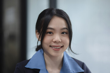 Asian woman smiling and looking at the camera.