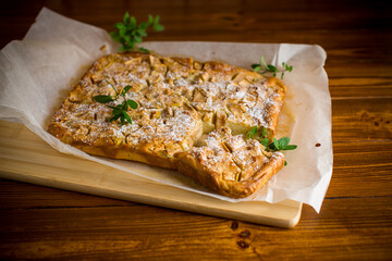 prepared curd semolina pie with quince inside and covered with powdered sugar .